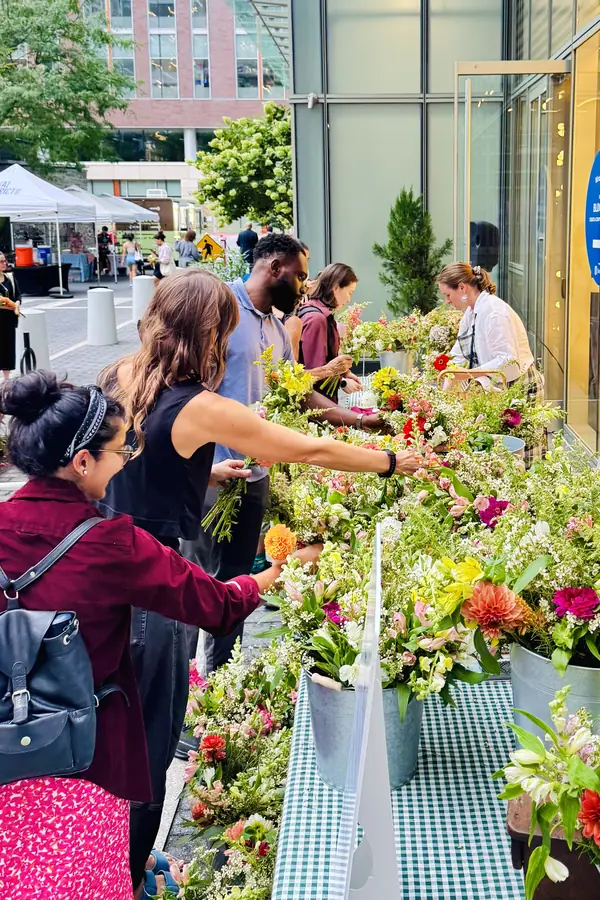 Guests choosing stems at the Cambridge Blooms bloom bar at an outdoor market